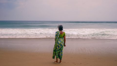 A woman stands on a beach in India