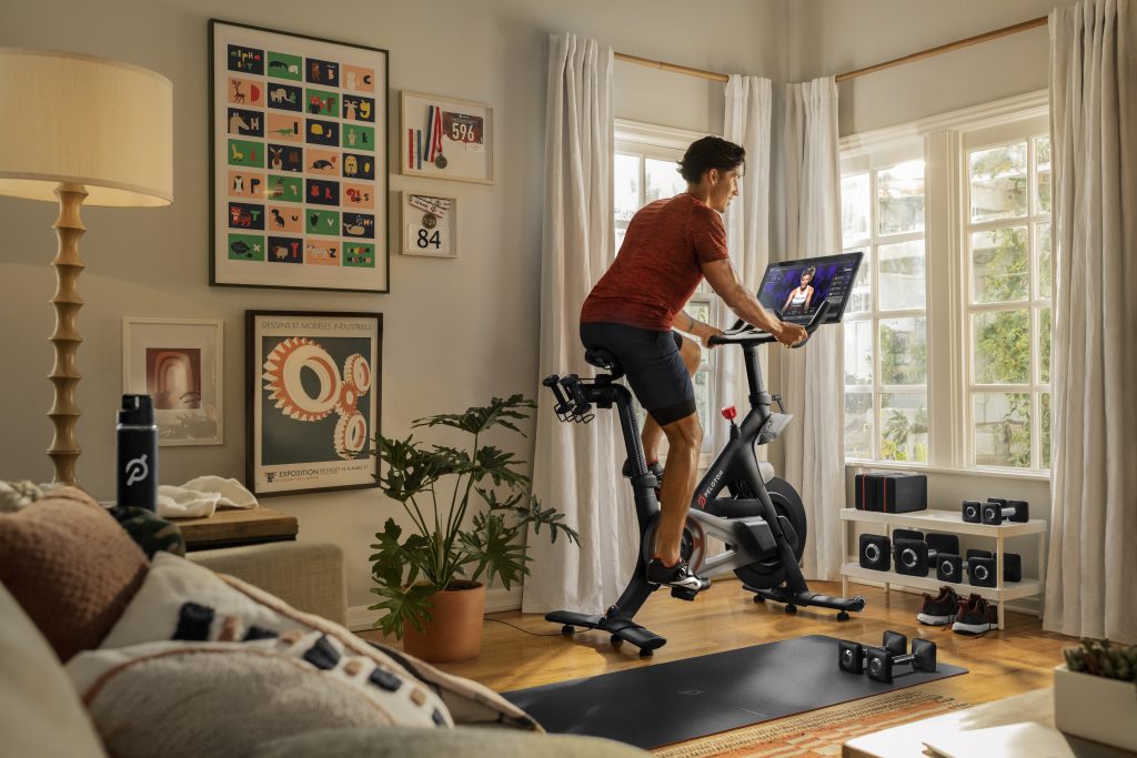 Photo of a man riding a Peloton bike in a room at home.