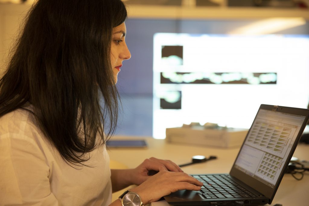 A Novartis employee types on a laptop keyboard. 