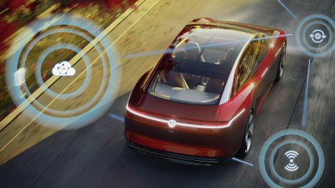 Aerial photo of red Volkswagen car with graphics superimposed on image depicting autonomous driving features.
