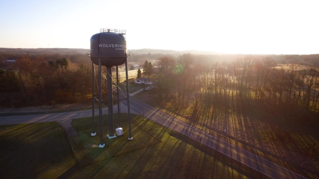 Sun shines on a water tower that carries the name Wolverine Worldwide