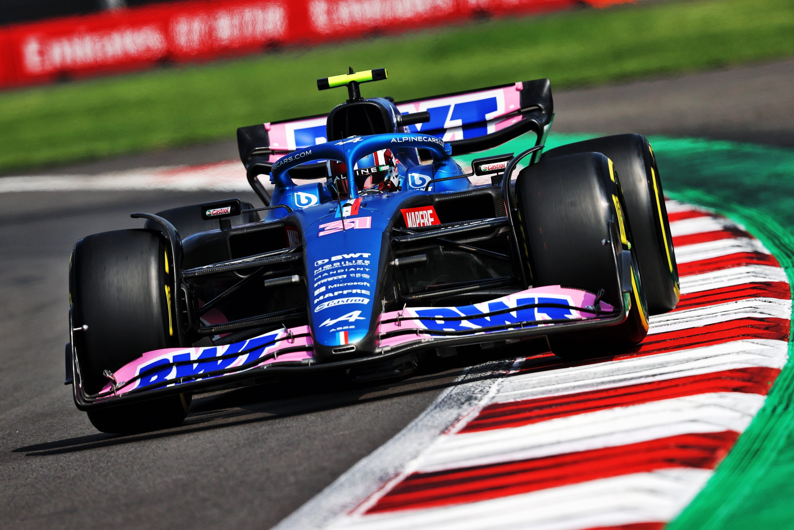 The car of Alpine driver Esteban Ocon banks left into a turn during a race.