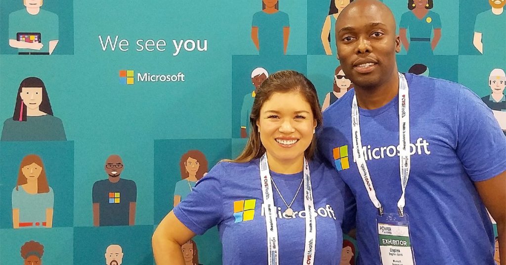two people wearing Microsoft shirts and smiling