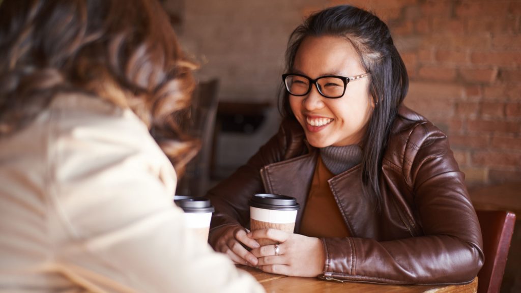 Women holding coffee cups and talking