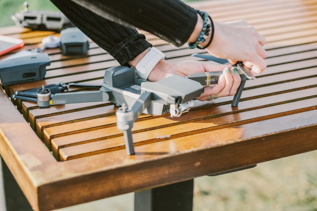 Hands working on a drone that is sitting on a table
