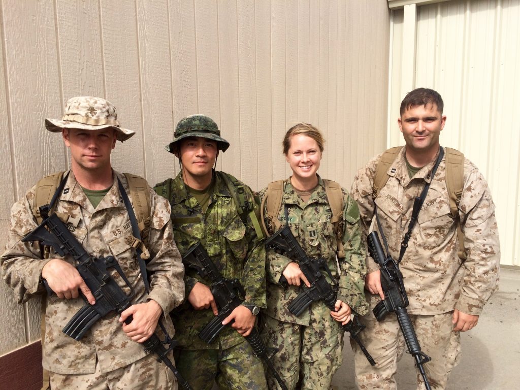 four people in uniform holding rifles