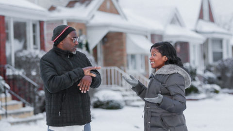 Royce Martin and Heather Dowdy having a conversation while standing in the snow outside their family home in Chicago.