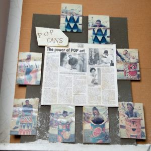 A photo of an old newspaper clipping hanging in artist Richard Thomas' studio showing photos from student projects.