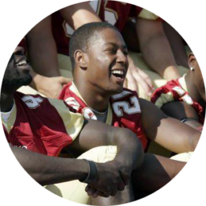 A young man wearing a red football jersey smiling