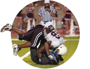 A high school football player tackles another player on a football field
