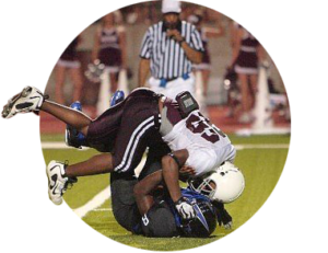 A high school football player tackles another player on a football field