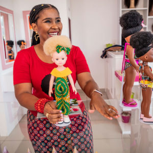 A woman holding a doll with albinism