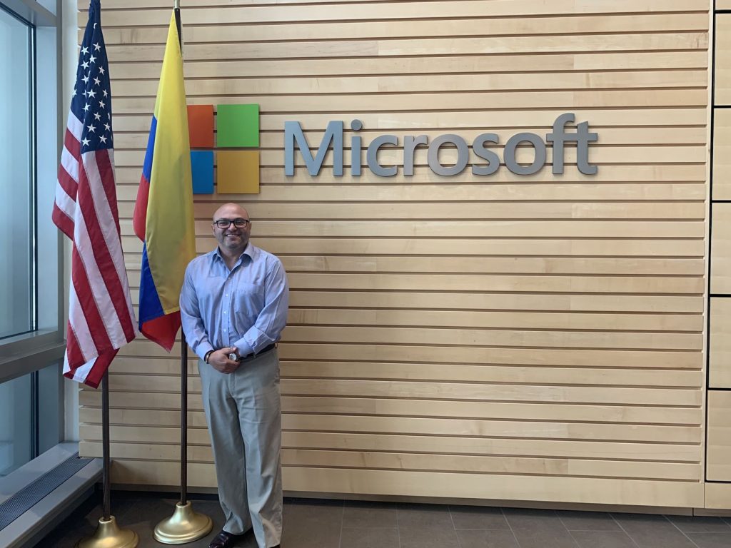 Joseph standing in front of a wall with a Microsoft banner.