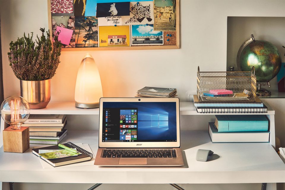 Ein modernes Acer Swift Notebook auf einem Schreibtisch in einer jugendlich eingerichteten Wohnung.