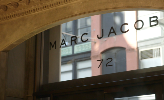 Das Foto zeigt den oberen Teil einer Tür, über der das Marc Jacobs Logo angebracht ist.