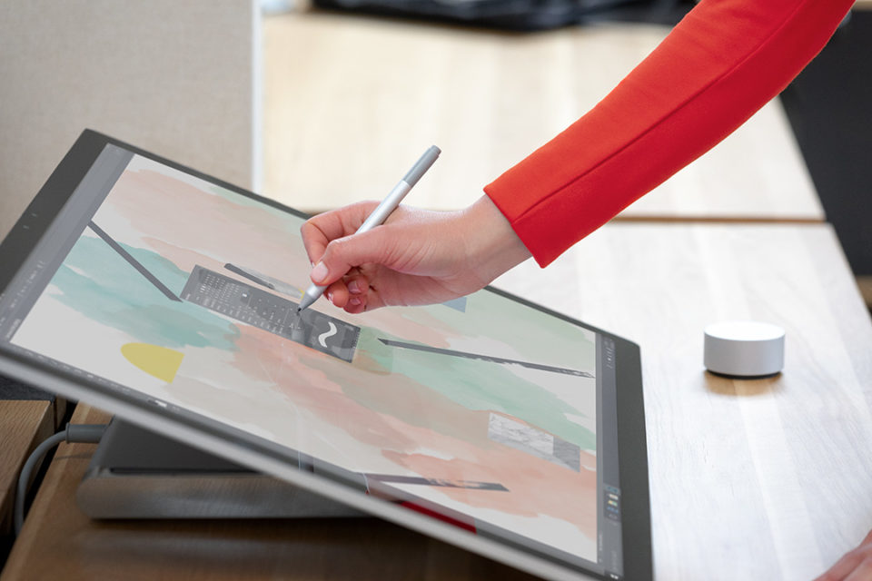 Kontextuelles Bild der Frau beim Zeichnen oder Tuschieren mit Surface Pen auf einem Surface Studio 2 am Schreibtisch.