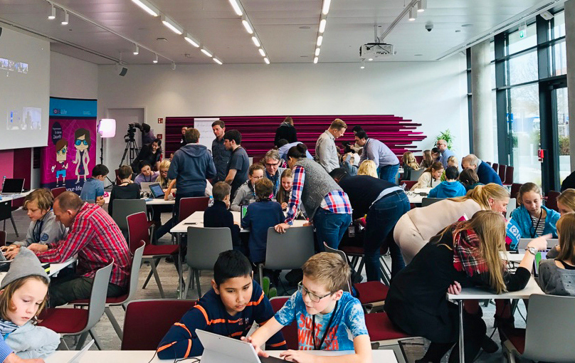 Bild eines Coding-Workshops mit einem Raum voller Teilnehmer, jung und alt.