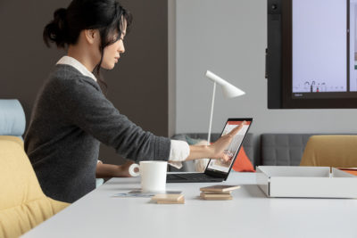 Frau arbeitet via Touch-Bedienung an einem Laptop