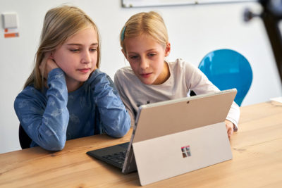 Zwei Kinder vor einem Microsoft Surface Laptop