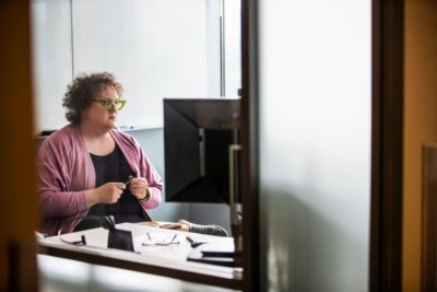 Eine Frau sitzt vor dem Computer und leistet Support
