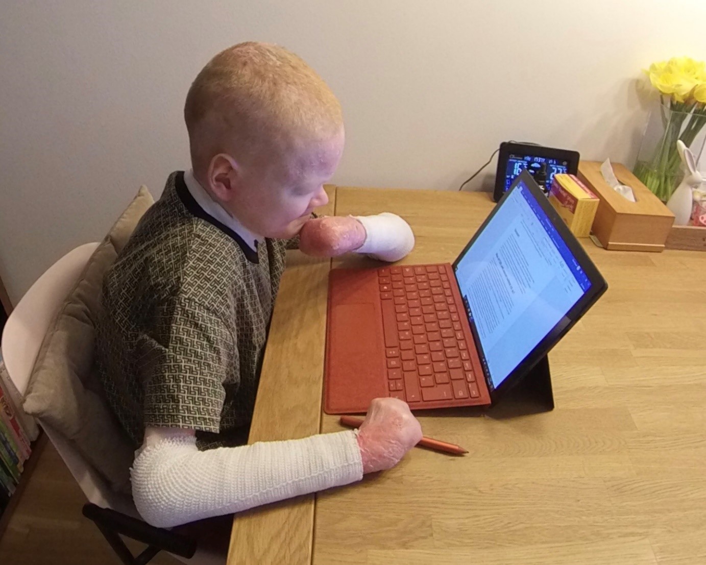 Pascal sitzt am Schreibtisch, vor ihm steht das Surface Pro 7.