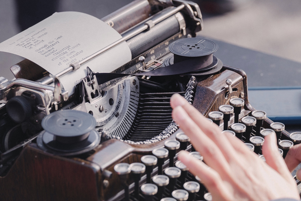 Eine Hand tippt auf einer Schreibmaschine