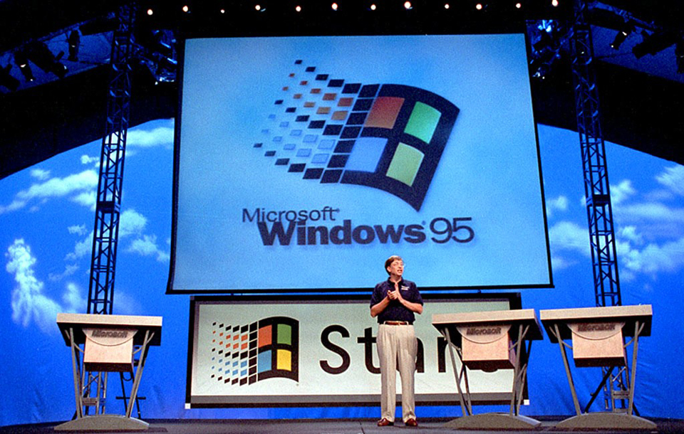 Bill Gates auf einer Bühne, im Hintergrund sieht man das Windows 95 Logo