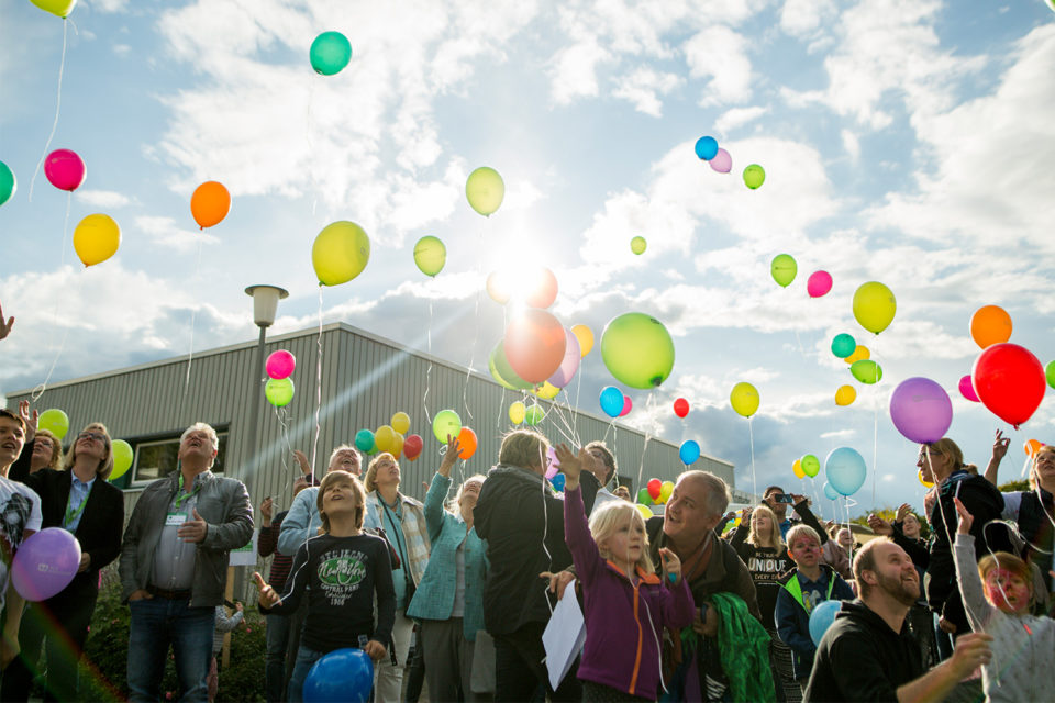 Kinder und Eltern lassen Luftballons in die Luft