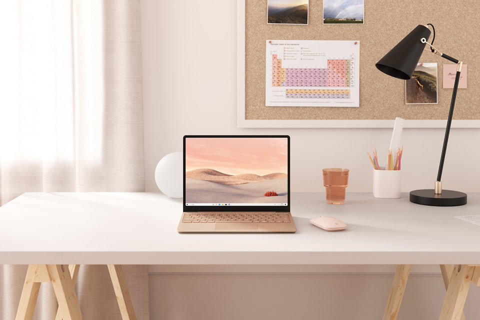 Surface Laptop Go in der Farbe Sandstein, auf einem Schreibtisch stehend