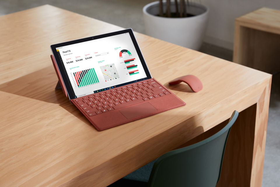 Surface Pro 7+ mit Type Cover, Stift und Maus steht auf einem Tisch mit heller Holzoberfläche