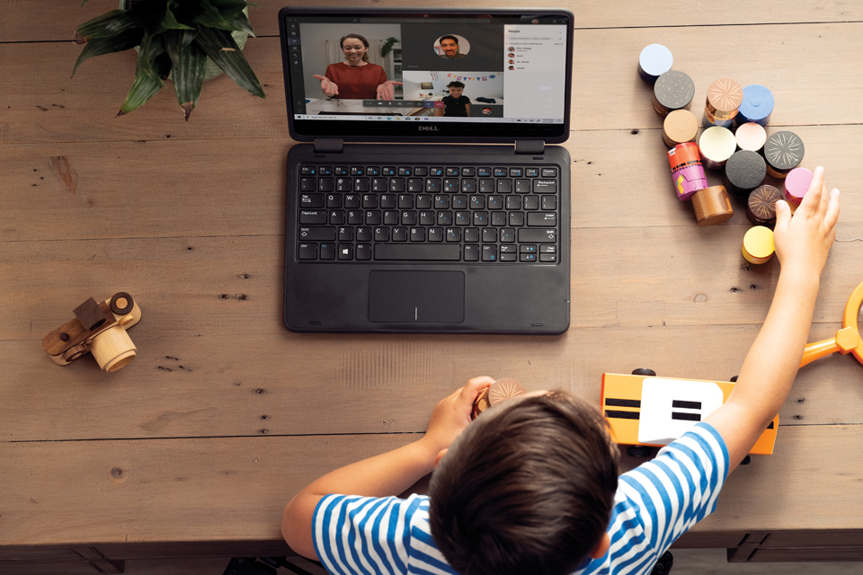 Schreibtisch von oben: Ein Kind lernt mit Windows 10 Laptop und Spielklötzen