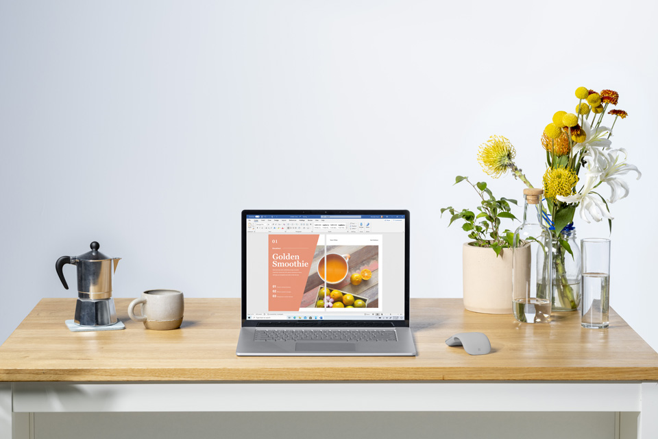 Surface Laptop 4 mit Kaffee und Blumen auf einem Holztisch