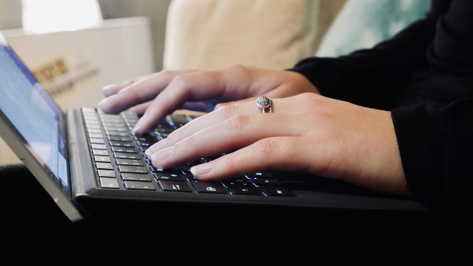Hände einer Frau auf einer Laptop-Tastatur
