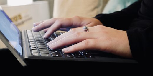 Hände einer Frau auf einer Laptop-Tastatur