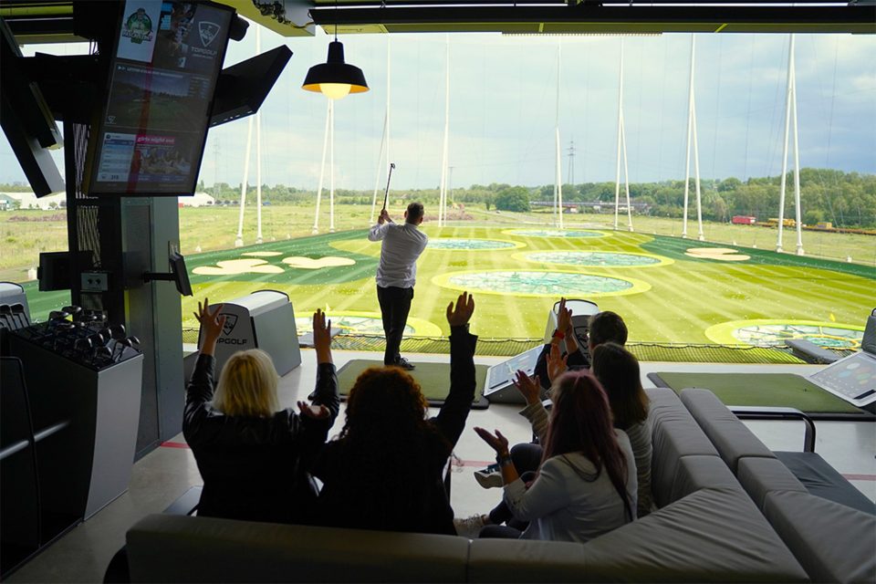 Impressionen aus einer Topgolfanlage, wo Gäste Golf spielen