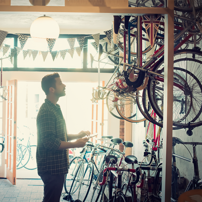 Mann schaut sich umgeben von Fahrrädern in einem Laden um