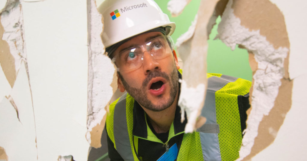 Un empleado de Microsoft observa a través de una pared de yeso demolida en el Edificio 2