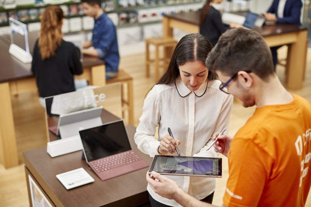 Empleados de Tienda Microsoft explican el uso de productos a los clientes