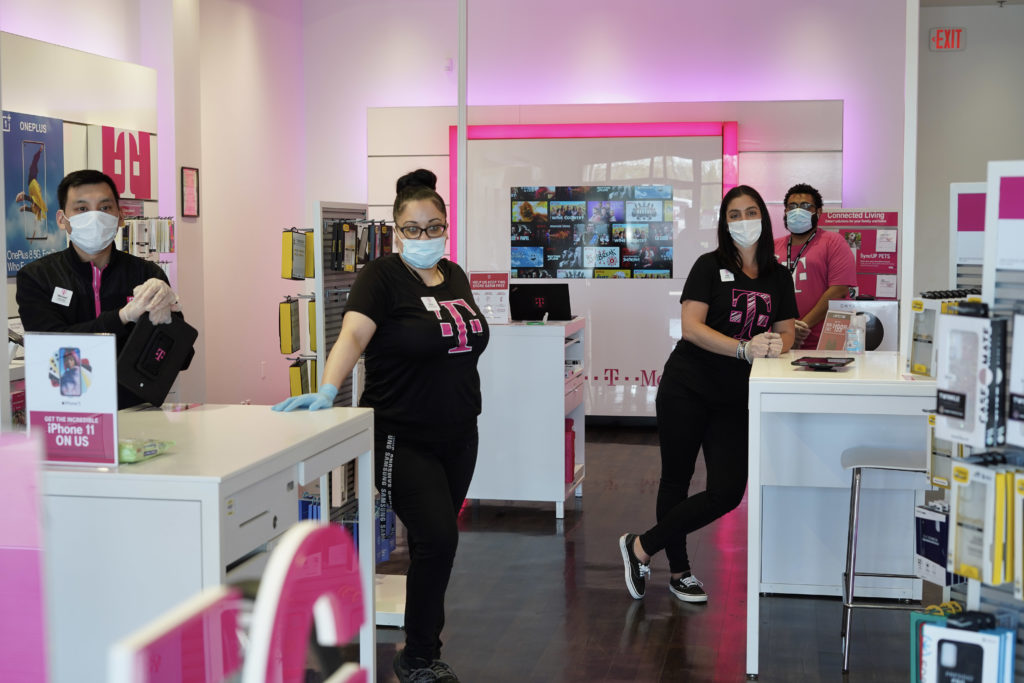 Empleados comerciales de T-Mobile con máscaras y guantes