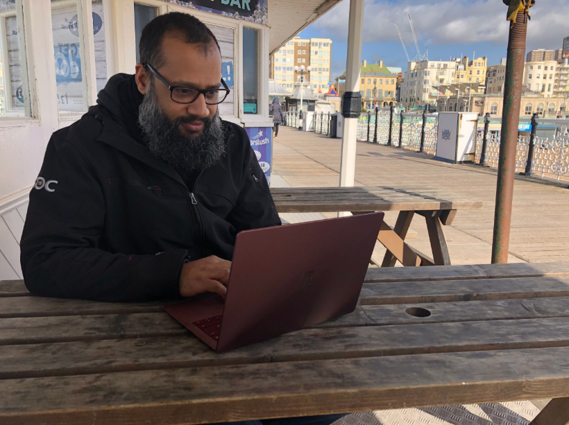 James Stone, desarrollador de videojuegos en el programa ID@Xbox, utiliza una laptop en Brighton Palace Pier