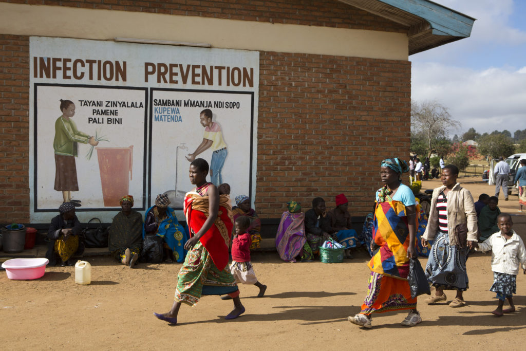 Foto que muestra a gente que camina en un edificio que alberga a una clínica de vacunación en Malawi.