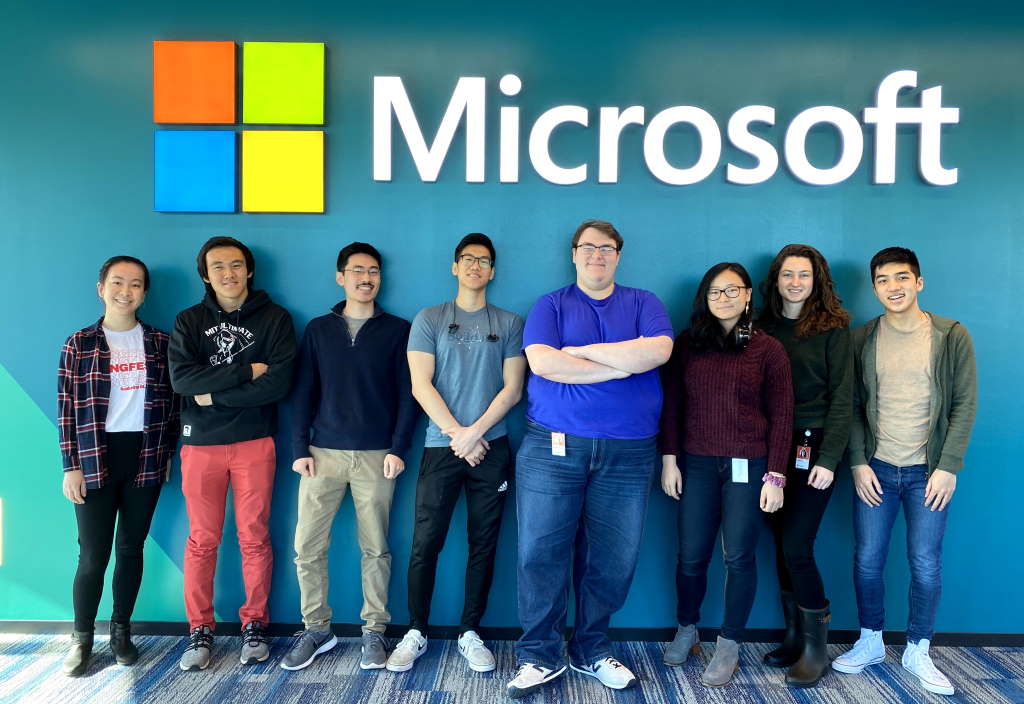 Practicantes del MIT frente a un letrero de Microsoft