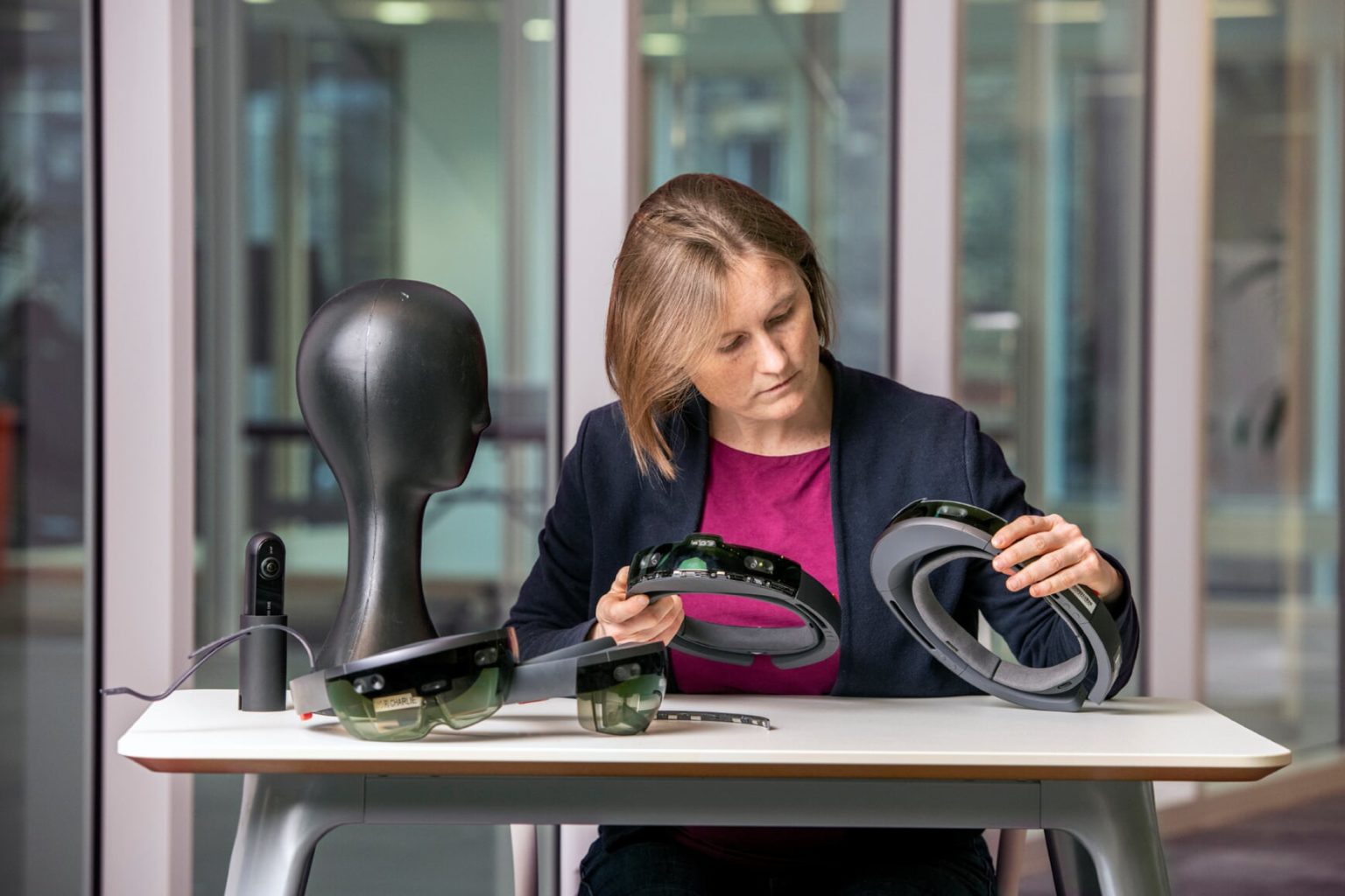 Cecilia Morrison sentada en una oficina mientras observa un dispositivo HoloLens