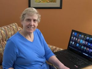 Retrato de una mujer sentada junto a su laptop