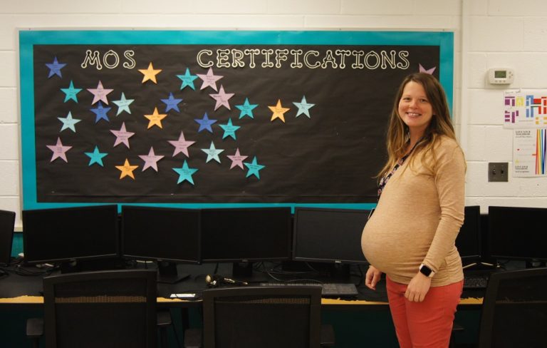Una mujer embarazada frente a un tablón de anuncios