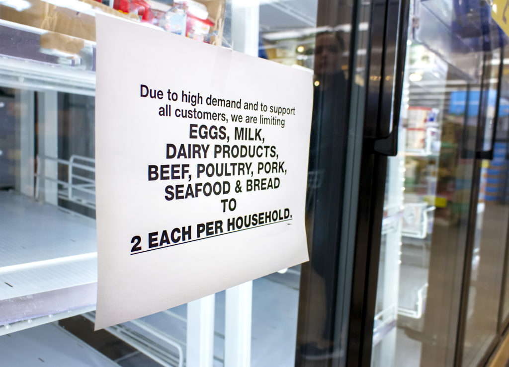 Un aviso en una tienda de comestibles que limita a los clientes durante la pandemia