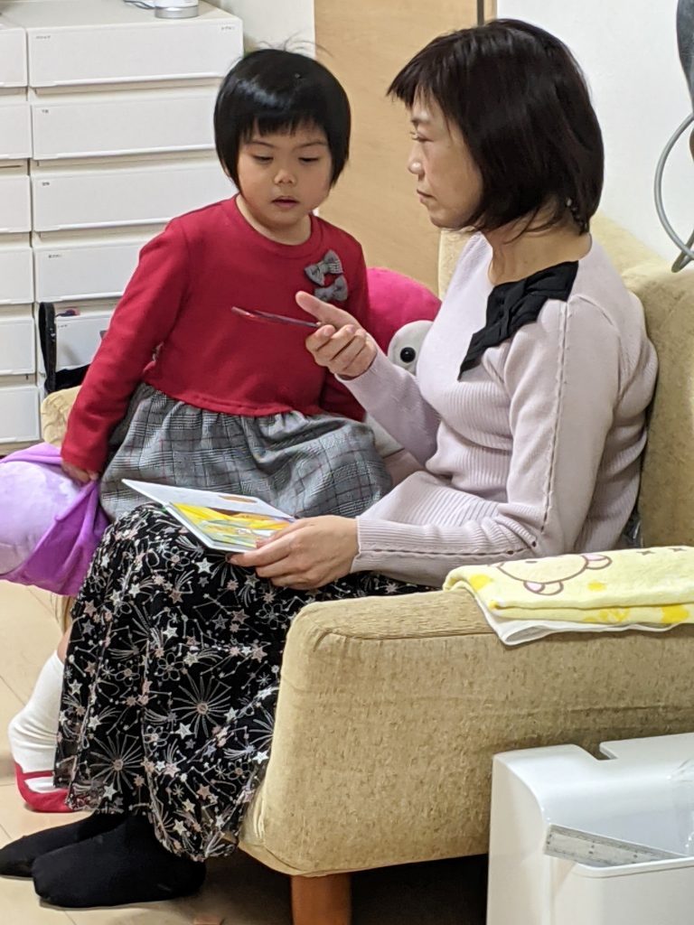 Una madre y su hija pequeña leen un libro