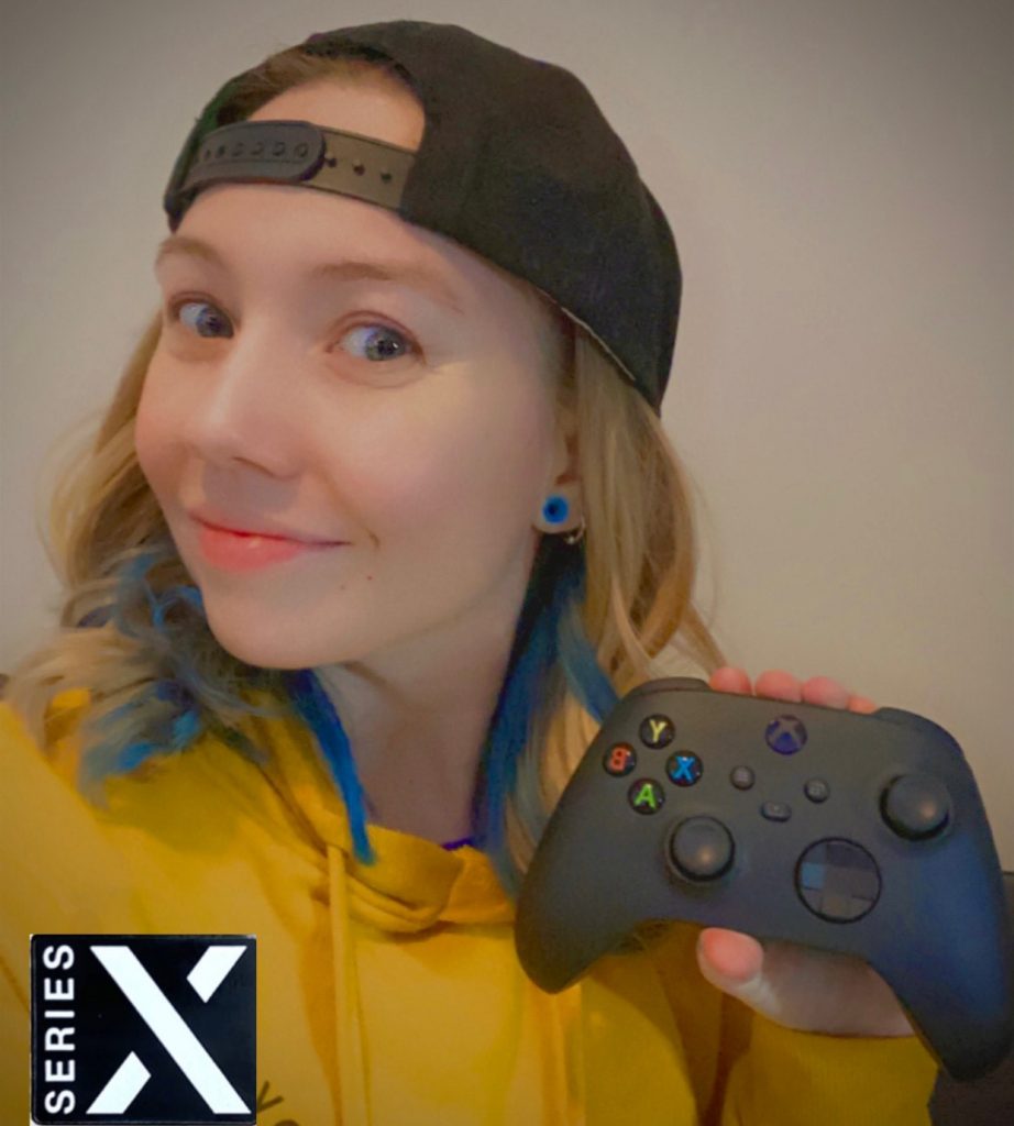 Marissa Urban sostiene un control de Xbox, usa una camiseta amarilla y una gorra al revés