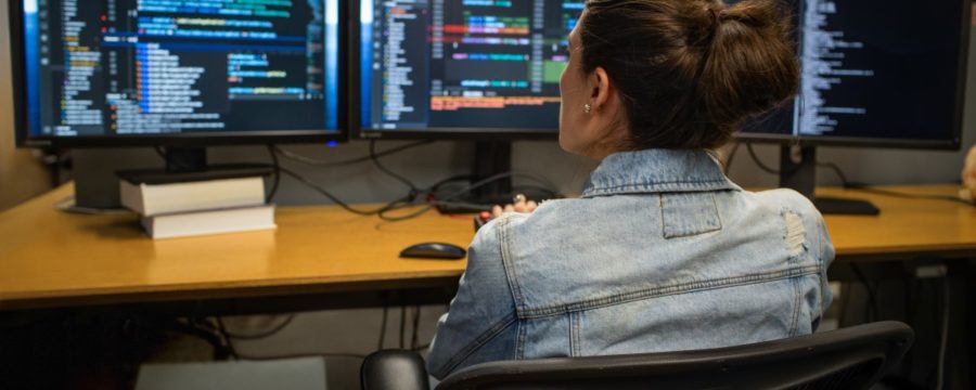 Una mujer desarrolladora codifica en su espacio de trabajo en una oficina.