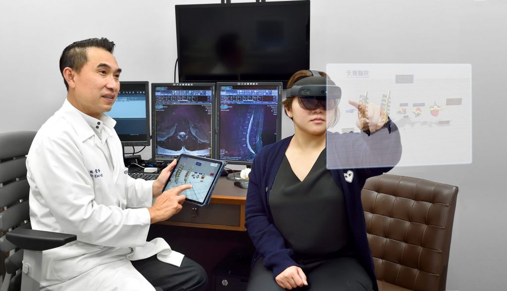 Una mujer opera un HoloLens mientras un hombre mira